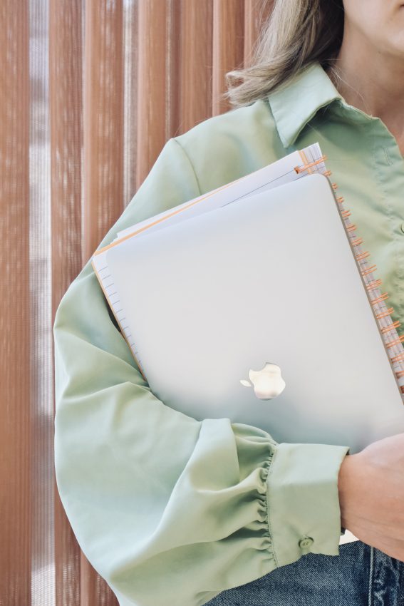 Emily holding her laptop and notebook