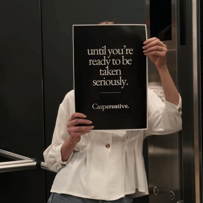 Emily holding a Cusp Creative sign